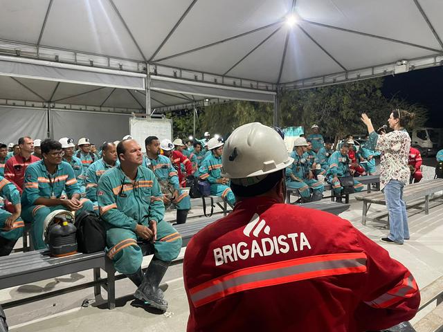 Karina conduz palestra para brigadistas e operadores sob uma tenda